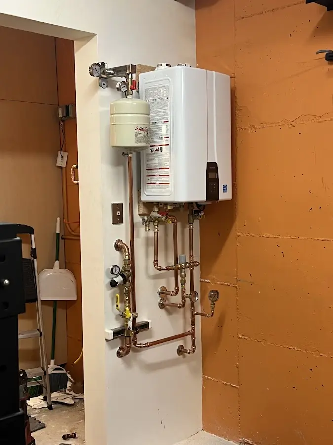 Plumbing technician inspecting water heater connections in Campbell